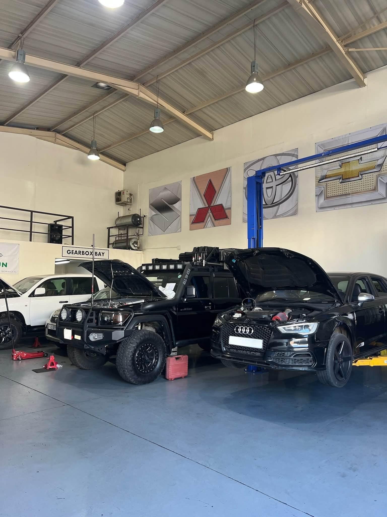 Vehicles with open bonnets inside the Scheün Automotive Services workshop